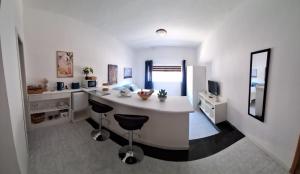 eine Küche mit einer weißen Kochinsel in einem Zimmer in der Unterkunft 56, Windchimes in Pembroke
