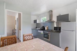 a kitchen with a refrigerator and a table in it at La Mailleraie - L'etang in Valojoulx