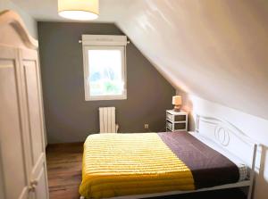 a bedroom with a bed with a yellow blanket at Grand Gîte Avec 2 Chambres in Saint-Pol-sur-Ternoise