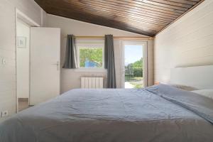 a bedroom with a large bed in front of a window at La Mailleraie - L'etang in Valojoulx +29 photos