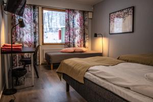 a bedroom with two beds and a window at Tanhuvaaran urheiluopisto & Sport Resort in Savonlinna +41 photos