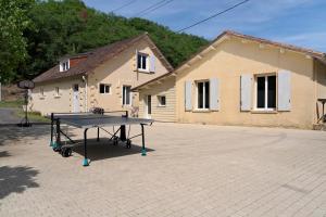 a ping pong table in front of a building at La Mailleraie - L'etang in Valojoulx