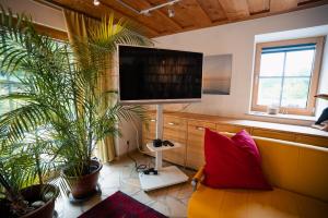 a living room with a couch and a flat screen tv at NaturQuartier am Stadtrand von Nürnberg in Stein