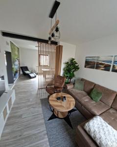 a living room with a couch and a table at Modernes Appartement nur 5 km von Erfurt, stilvoll komfortabel und perfekt angebunden, Kaffeevollautomat, TV, WLAN, Schlafsofa und Einkaufsmöglichkeiten in der Nähe, hervorragende Anbindung zur A4 und A71, kostenlose öff Parkplätze für PKW und Transporter in Elxleben