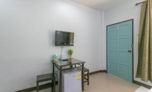 a room with a refrigerator and a tv on the wall at Chaiyo Riverfront Resort Phuket in Phuket
