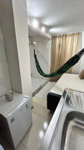 a bathroom with a hammock in a room with a sink at Fenomenall Kitnet in Campina Grande