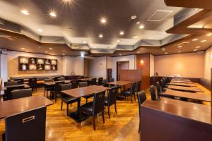 a restaurant with tables and chairs in a room at Alpico Plaza Hotel in Matsumoto