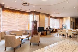 a waiting room with tables and chairs and a clock at Alpico Plaza Hotel in Matsumoto +52 photos