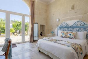 a bedroom with a bed and a large window at Giardino Frannicola in Maglie