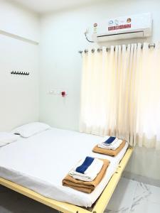 a hospital room with a bed with towels on it at Book the Entire Villa or Choose a Room for a Comfortable Homestay Experience in Solapur +3 photos