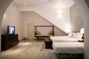 a attic room with two beds and a couch at Villa Labugolla in Kandy