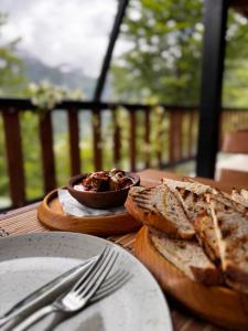 a table with a bowl of bread and a bowl of food at Thethi Paradise Hotel & Restaurant in Theth