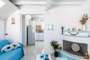a living room with a blue couch and a fireplace at Pastalia Cottage in Skopelos Town