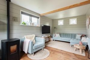 a living room with a blue couch and a fireplace at Boshuis Luna | 4 persons in Gasselte