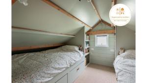 two beds in a bedroom with a roof at Boshuis Luna | 4 persons in Gasselte