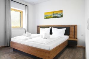 a bedroom with a large bed with white sheets at Rote Villa Füssen in Füssen