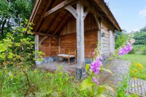 a wooden cabin with a bench in a garden at Boshuis Luna | 4 persons in Gasselte