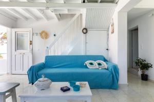 a living room with a blue couch and a table at Pastalia Cottage in Skopelos Town