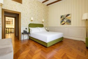 a bedroom with a large white bed and wooden floors at Villa Lena Puglia in Oria