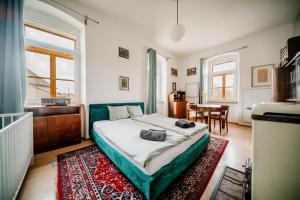 a bedroom with a bed and a dining room at Penzion Sborovna in Zbraslavice