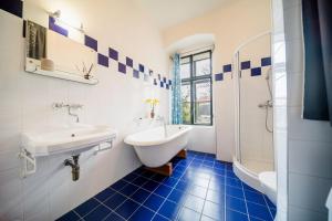 a bathroom with a sink and a tub and a toilet at Penzion Sborovna in Zbraslavice