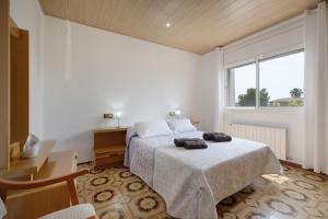 a bedroom with a bed and a large window at Casa Gemina in Deltebre