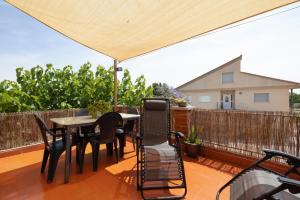 a patio with a table and chairs and an umbrella at Casa Gemina in Deltebre