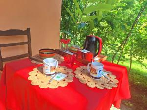 a red table with cups and plates on a red table cloth at Villa Paradis in Sainte Marie