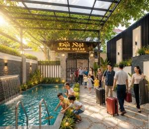 a group of people standing around a swimming pool at Đại Nội Saphia Homestay & Villa in Hue