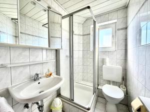 a bathroom with a sink and a toilet and a shower at Midway Weser Hotel Nienburg in Nienburg