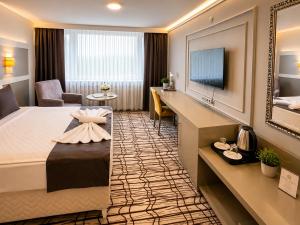 a hotel room with a king sized bed and a desk at Burcman Hotel in Bursa