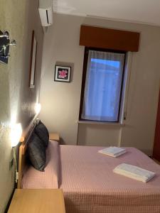 a small bedroom with a bed and a window at Hotel Ristorante Lilia in Verona