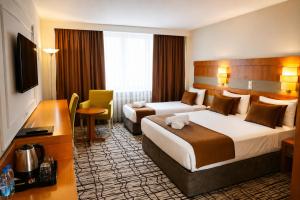 a hotel room with two beds and a desk at Burcman Hotel in Bursa +36 photos