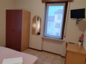 a bedroom with a bed and a window and a desk at Hotel Ristorante Lilia in Verona