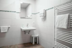 a white bathroom with a sink and a mirror at Rote Villa Füssen in Füssen