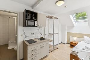 a kitchen with a sink and a microwave in a room at Jenapartments Pension - Studios mit Küche in Jena +28 photos
