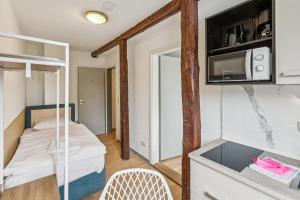 a small room with a bunk bed and a microwave at Jenapartments Pension - Studios mit Küche in Jena