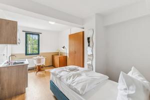 a bedroom with a bed and a sink in it at Jenapartments Pension - Studios mit Küche in Jena