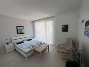 a bedroom with a bed and a table and a chair at Aroeira Villa B&B in Charneca