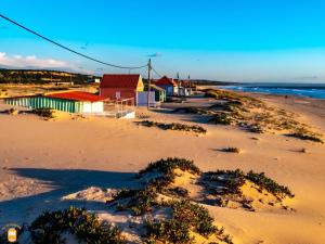 a beach with some buildings and the ocean at Aroeira Villa B&B in Charneca