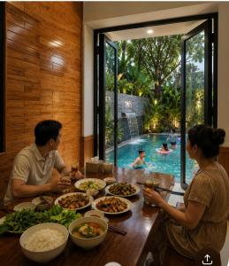 a group of people sitting at a table with food at Đại Nội Saphia Homestay & Villa in Hue