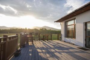 a wooden deck with tables and chairs on a house at Kayak Camp, Tsonjinboldog in Yoliin Hural