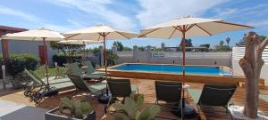 a patio with chairs and umbrellas and a swimming pool at Bed & Breakfast La Villetta in Botricello