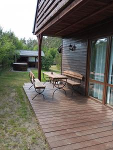 a wooden deck with a picnic table and benches at Domek Rokitki in Rokity