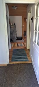 a hallway with a door open to a room with a rug at Järvitalo in Soini
