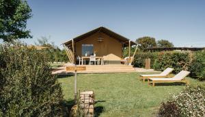a small house with a table and chairs in a yard at InMaremma glamping in Pescia Romana