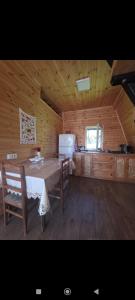 a kitchen with a table and chairs in a cabin at Cottage Irko in Tvebishi