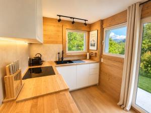 a kitchen with wooden walls and wooden floors and windows at L'Aiglon- Piscine Naturelle Privatisable in Salvan