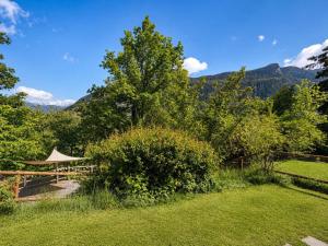a garden with a picnic table and mountains in the background at L'Aiglon- Piscine Naturelle Privatisable in Salvan
