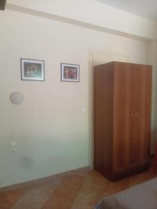 a room with a wooden cabinet and two pictures on the wall at Evriaki Rooms Lesvos in Gera +7 photos